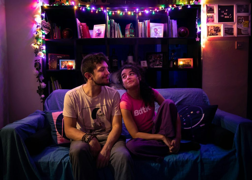 Couple sitting apart on a couch during a tense conversation